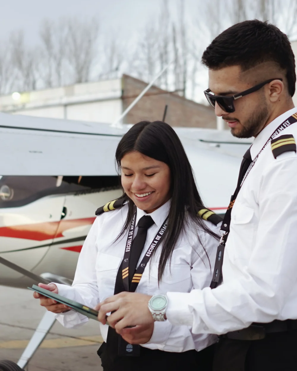 Estudiantes de Dream Fly revisando material de vuelo junto a una aeronave