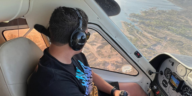 piloto con audífonos dentro de la cabina de un avión en pleno vuelo