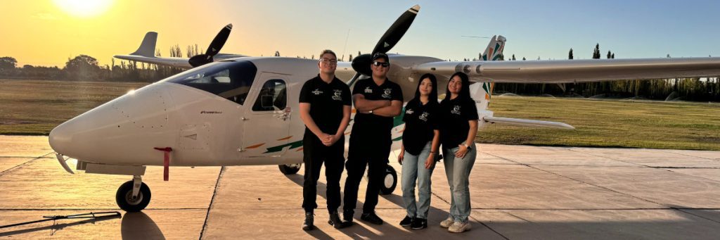 Grupo de estudiantes pilotos de Dream Fly posando frente a una aeronave en la pista, listos para su entrenamiento.