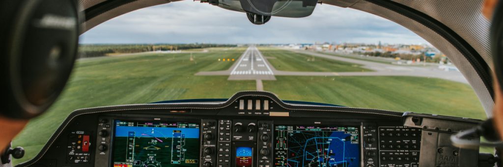 Vista desde la cabina de un avión por aterrizar, ilustrando los factores que determinan el sueldo piloto Colombia.